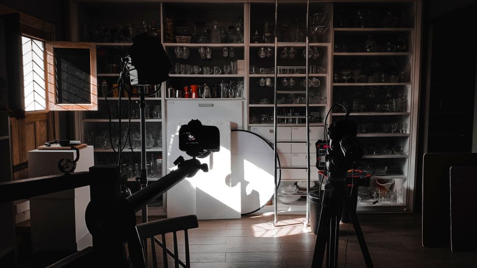 Interior view of a photography studio with cameras, lights, and equipment setup for a shoot.