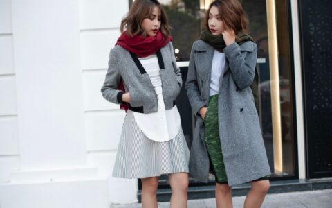 Two stylish women wearing winter coats and scarves, enjoying a day out.