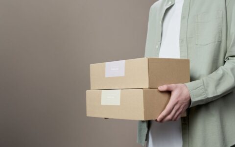 Close-up of a person holding thank you labeled boxes, ideal for delivery themes.